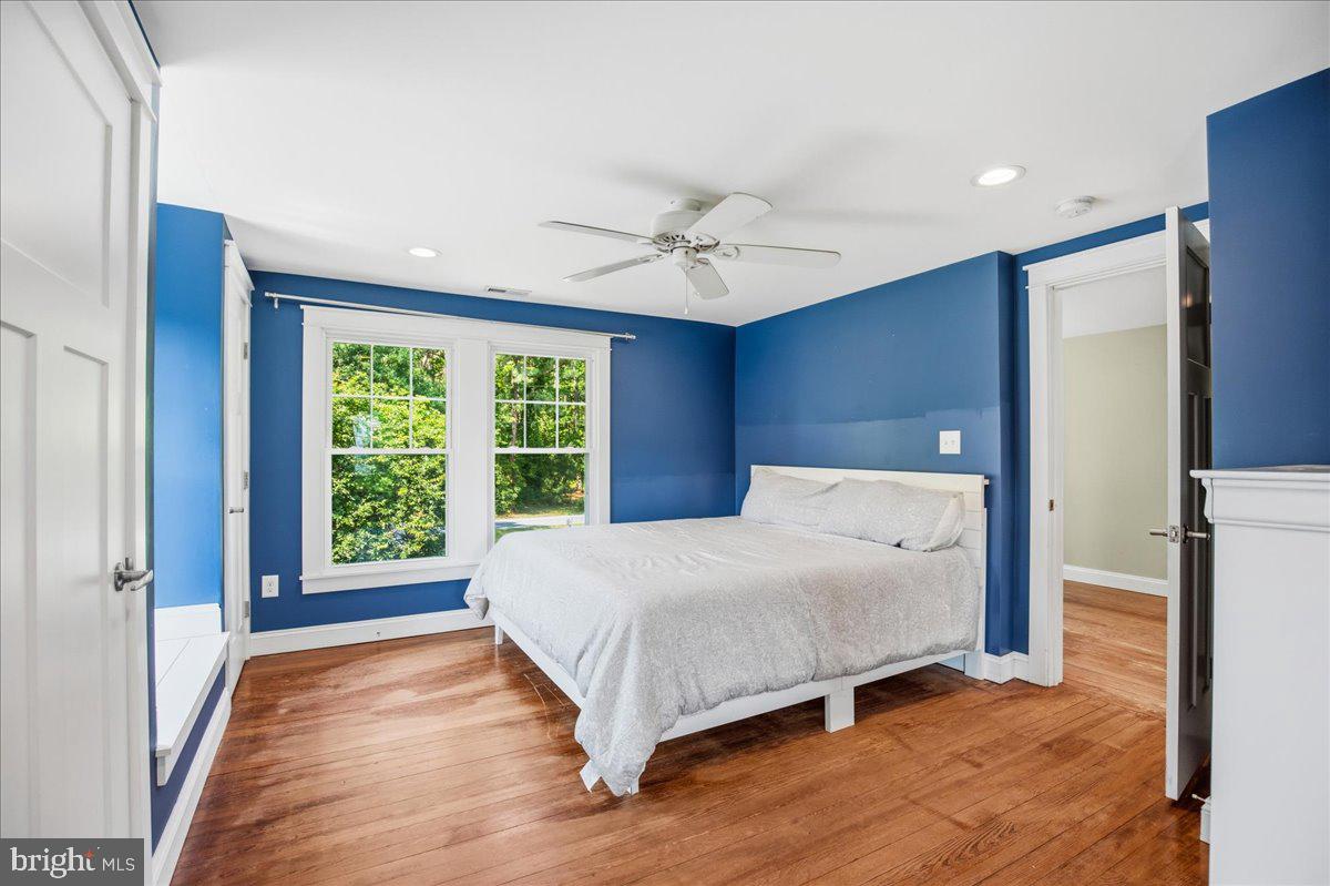 16146 Thomas Road Piney Point, MD 20674 - Photo 52 of 70 a spacious bedroom with a large bed and a chandelier