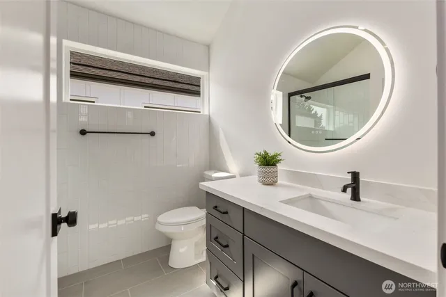 a bathroom with a toilet a sink and mirror