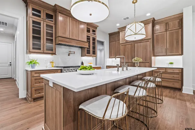 a kitchen with stainless steel appliances granite countertop a table chairs and a refrigerator