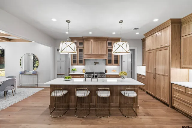 a kitchen with a dining table chairs stainless steel appliances and chandelier