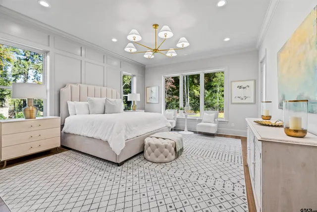 a spacious bedroom with a large bed and a chandelier