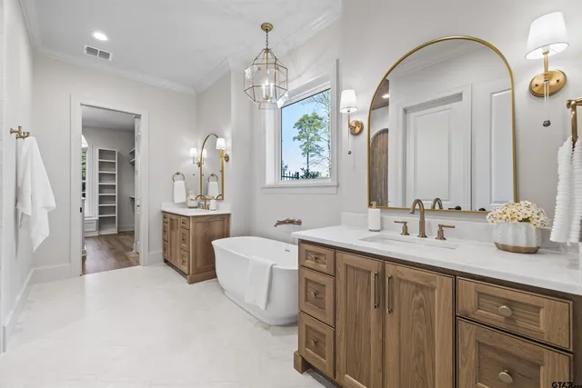 a spacious bathroom with a double vanity sink a mirror and bathtub