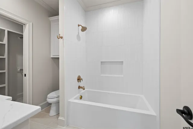 a white bath tub sitting next to a toilet