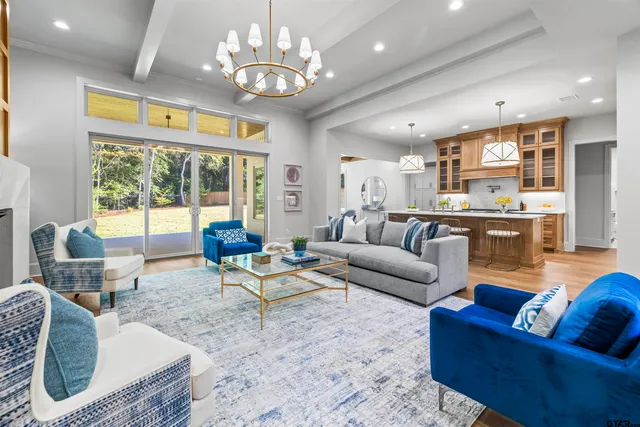 a living room with furniture chandelier and a large window