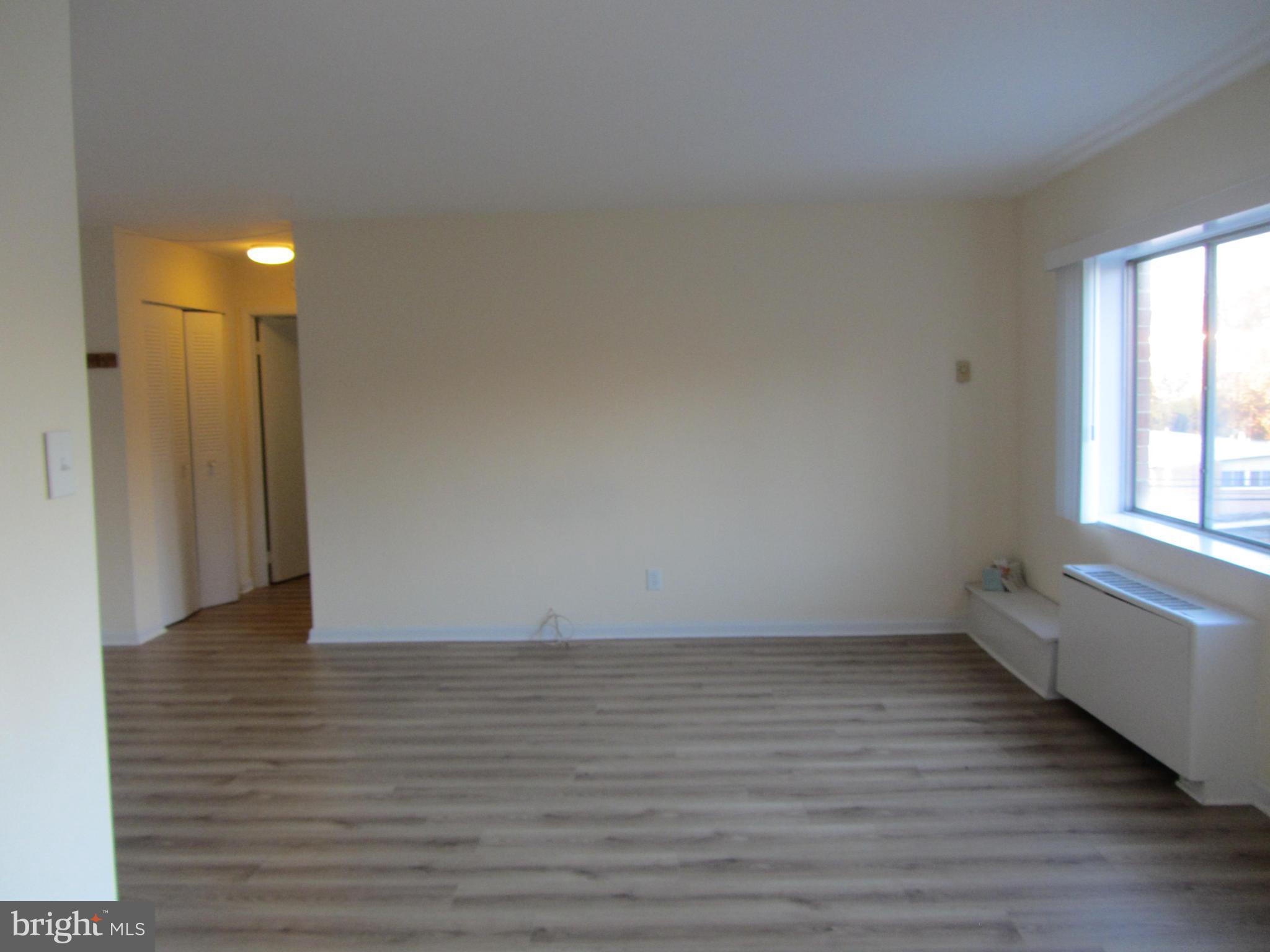 614 Sligo Avenue, Unit 303 Silver Spring, MD 20910 - Photo 13 of 31 a view of an empty room with wooden floor and a window