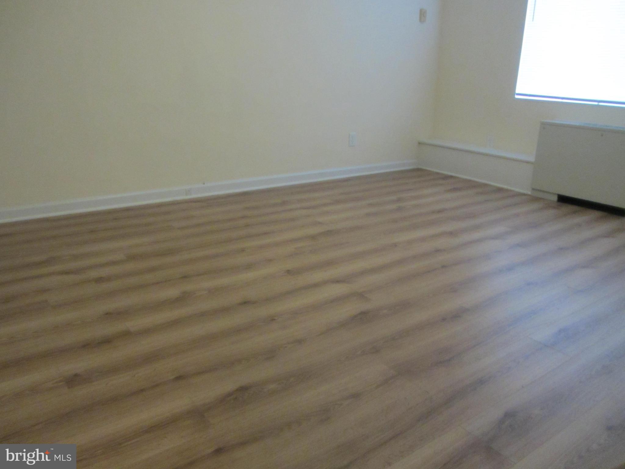 614 Sligo Avenue, Unit 303 Silver Spring, MD 20910 - Photo 27 of 31 a view of an empty room with wooden floor and a window