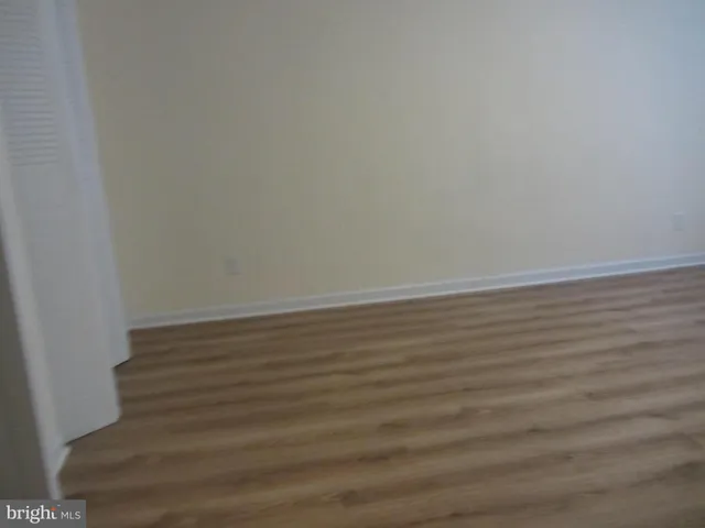 a view of a room that has wooden floor and a window