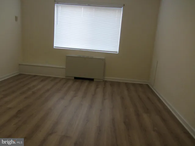 a view of a room with wooden floor and a window