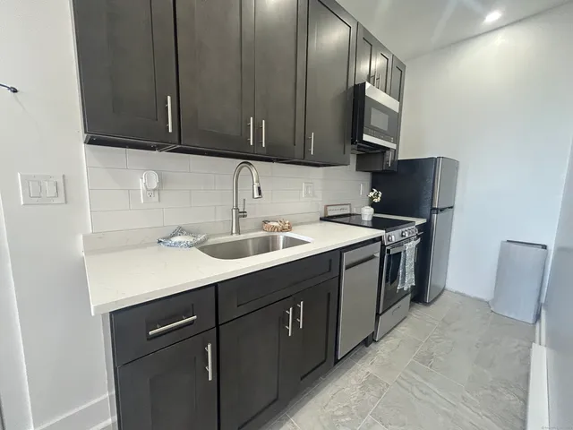 a kitchen with a sink cabinets and stainless steel appliances