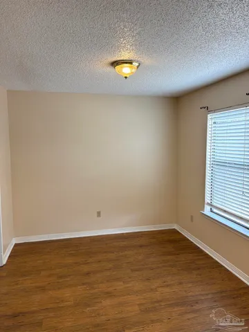 a view of a room with wooden floor and a window