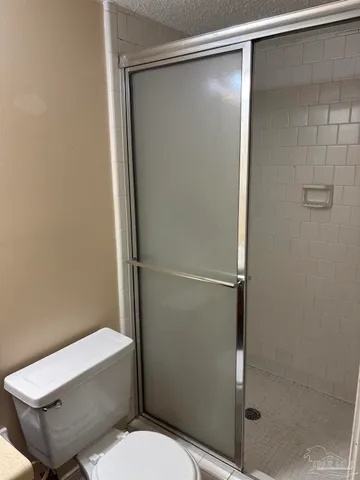 a white toilet sitting next to a shower