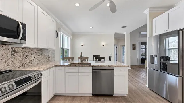 a kitchen with stainless steel appliances granite countertop a stove a sink and a microwave