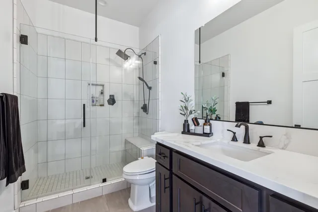 a bathroom with a sink a toilet and shower