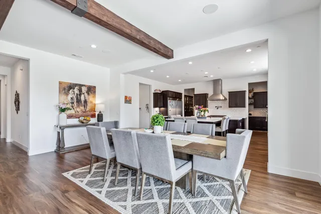 a view of a dining room with furniture wooden floor and a kitchen