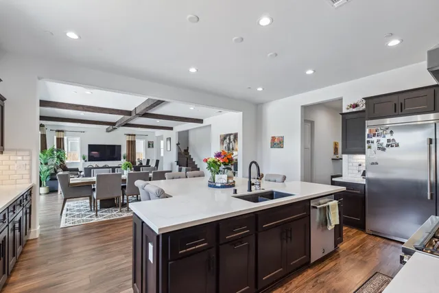 a kitchen with a sink appliances and wooden floor