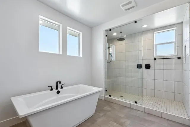 a white bath tub sitting next to a shower