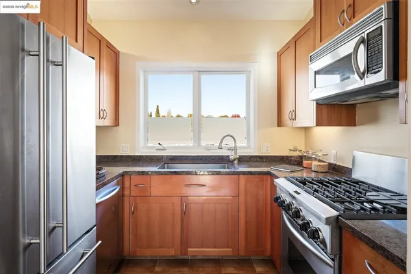 a kitchen with stainless steel appliances granite countertop a stove a sink and a microwave