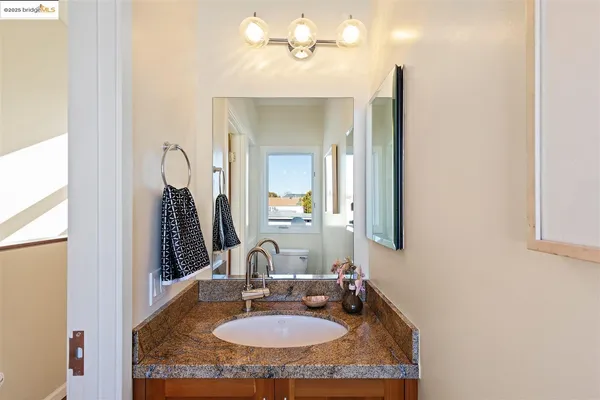 a bathroom with a granite countertop sink and a mirror