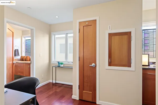a view of a hallway with dining room and wooden floor