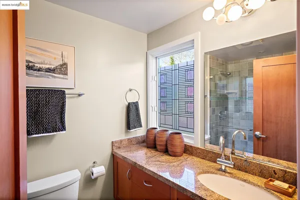 a bathroom with a granite countertop sink toilet and shower
