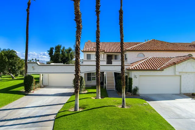 a view of a house with a floor to ceiling windows and a wooden fence
