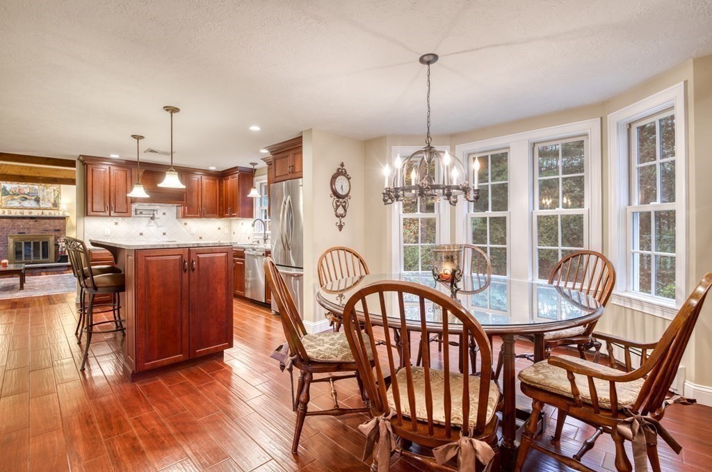 a dining room with furniture a chandelier and wooden floor