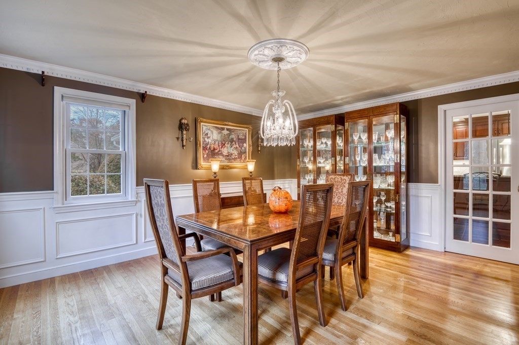 20 Clark Circle Hanover, MA 02339 - Photo 9 of 35 a dining room with wooden floor a chandelier a wooden table and chairs