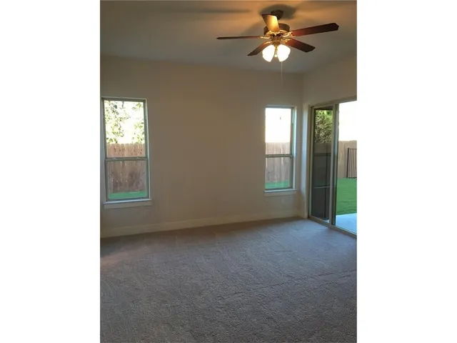 a view of a room with a ceiling fan and a window