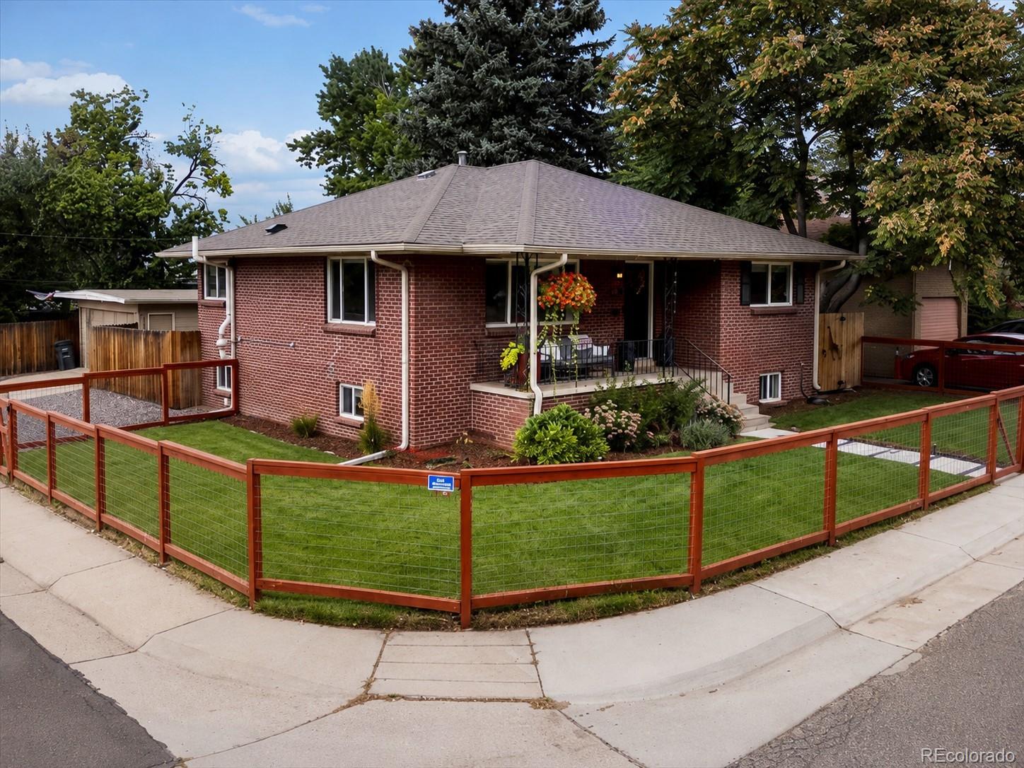 4963 North Harlan Street Wheat Ridge, CO 80033 - Photo 1 of 42 a front view of a house with garden