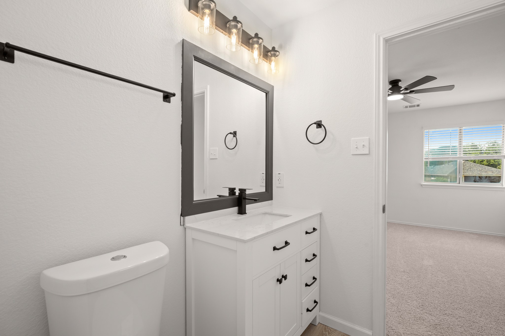 360 Sampson Kyle, TX 78640 - Photo 17 of 36 Bathroom vanity featuring a white cabinet, integrated sink, and dark-finish hardware