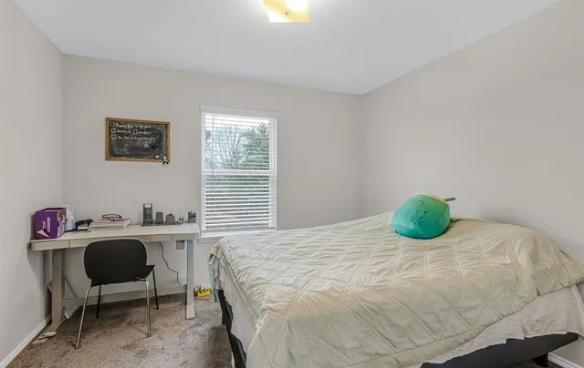 a bedroom with a bed and a desk