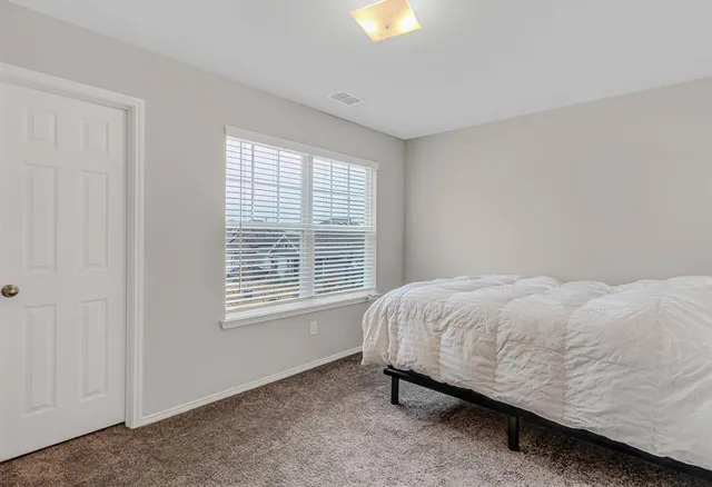 a bed sitting in a bedroom next to a window
