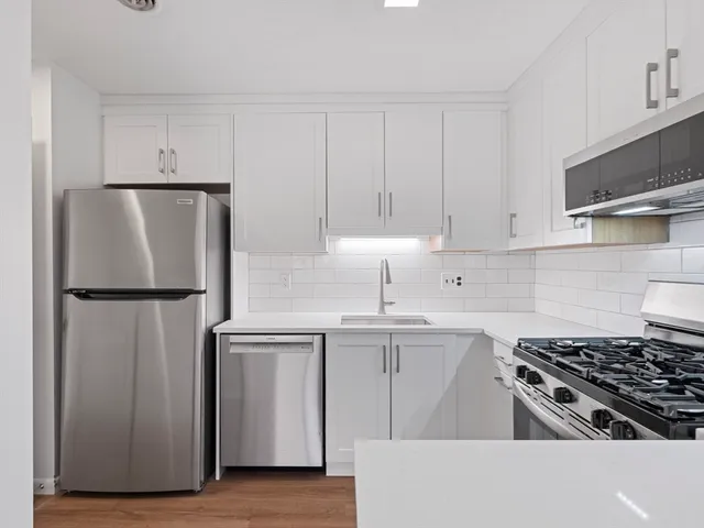 a kitchen with a refrigerator sink and cabinets
