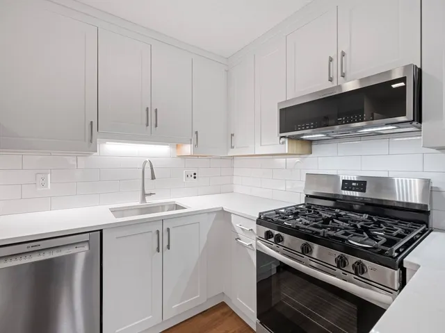 a kitchen with stainless steel appliances a sink a stove and microwave
