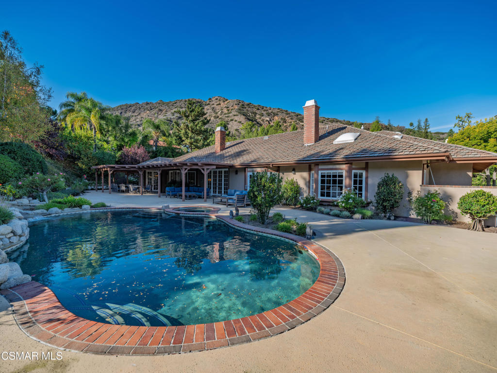 a view of a house with swimming pool and sitting area