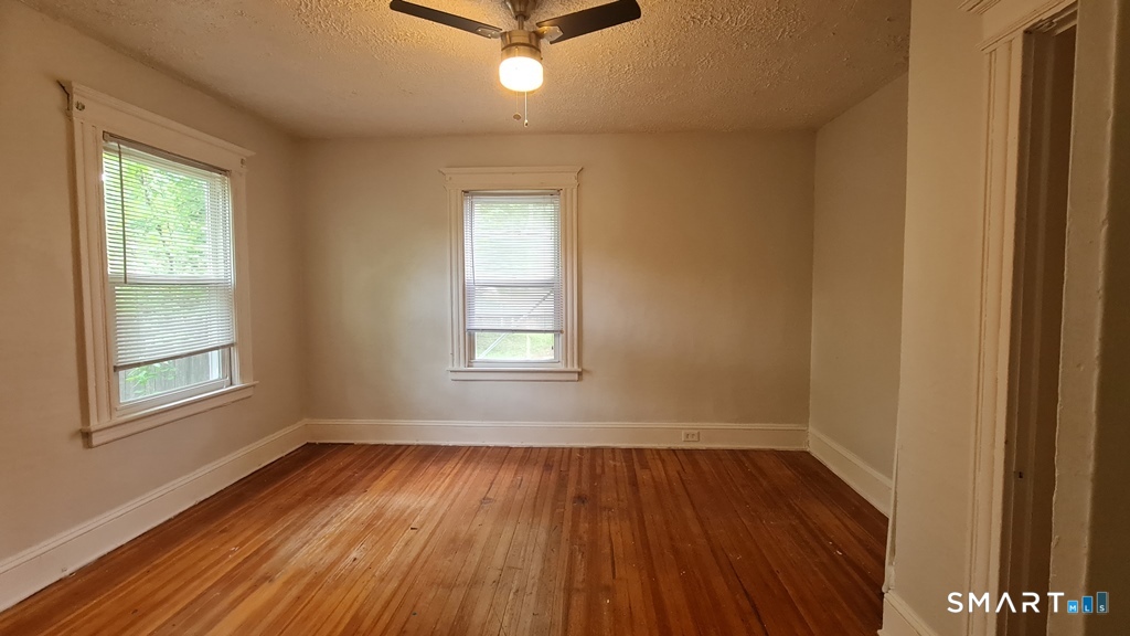 64-66 Ridge Street Manchester, CT 06040 - Photo 10 of 21 an empty room with wooden floor and windows