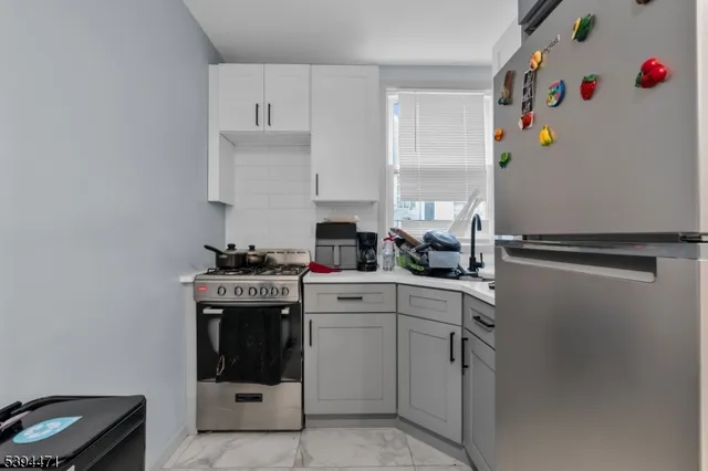 a kitchen with white cabinets and white appliances
