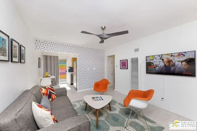 a living room with furniture and a wall painting