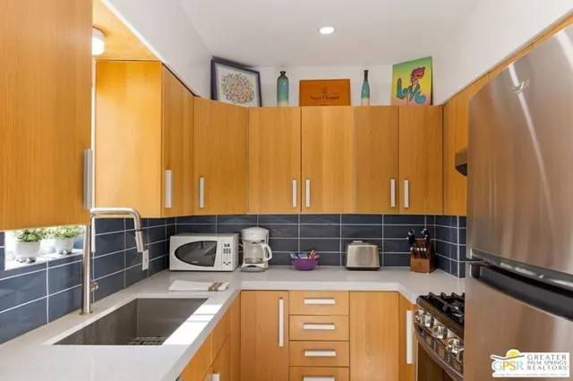 a kitchen with stainless steel appliances a sink a stove and a refrigerator