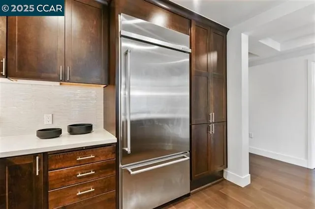 a kitchen with a refrigerator and wooden cabinets