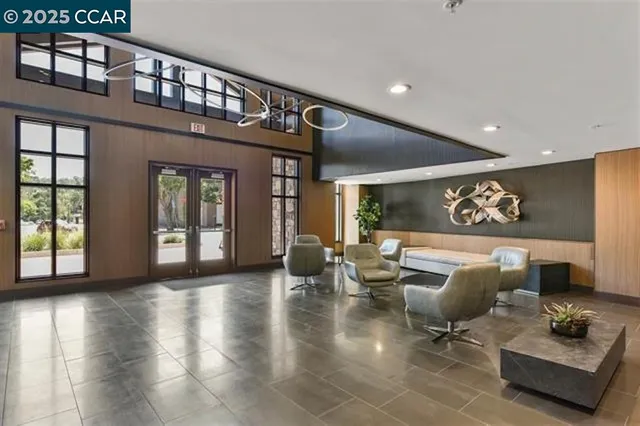 a living room with couches and a large mirror with wooden floor