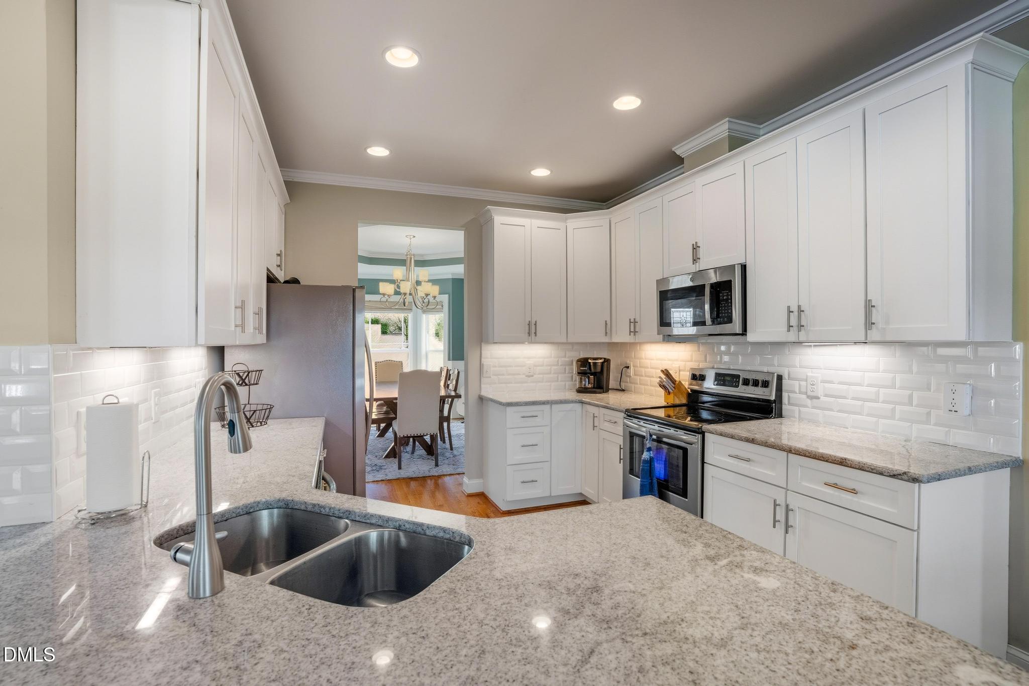 141 Vibernum View Four Oaks, NC 27524 - Photo 2 of 18 a kitchen that has a sink cabinets counter top space stainless steel appliances