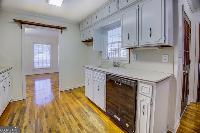 a kitchen with wooden floors and white appliances