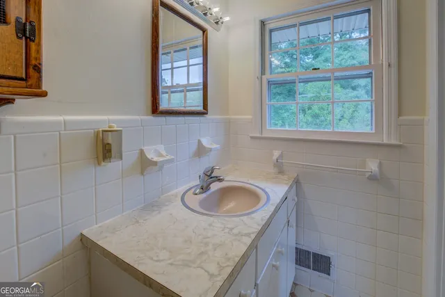 a bathroom with a granite countertop sink and a mirror