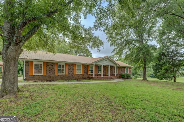 a front view of house with yard and green space
