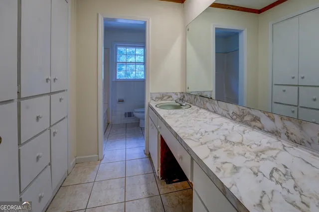 a bathroom with a granite countertop sink and mirror