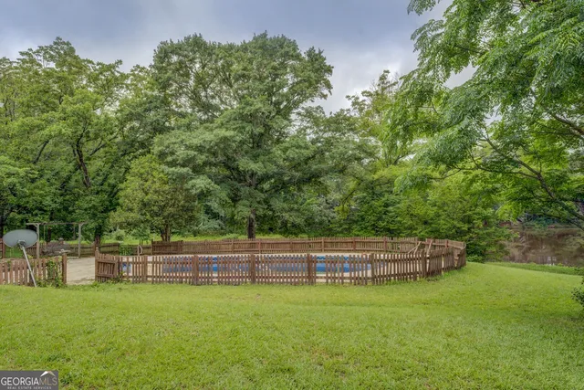 a backyard of a house with lots of green space and fountain
