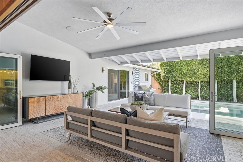 1205 Bryant Road Long Beach, CA 90815 - Photo 37 of 69 a living room with furniture a flat screen tv and a floor to ceiling window