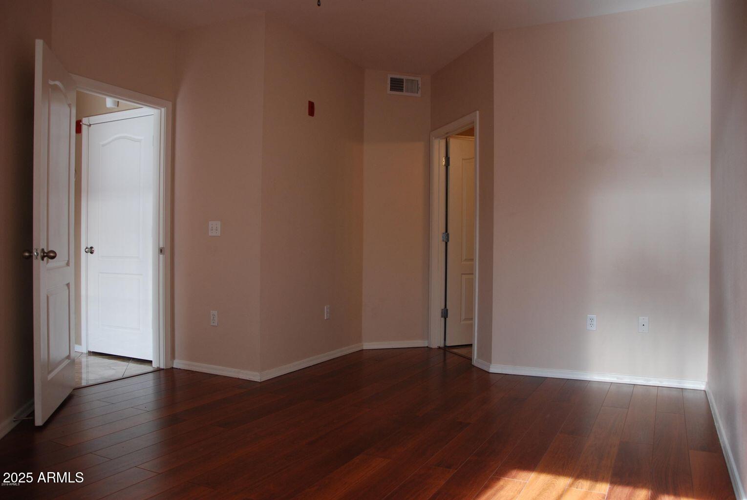 1701 East Colter Street, Unit 378 Phoenix, AZ 85016 - Photo 10 of 41 an empty room with wooden floor and closet