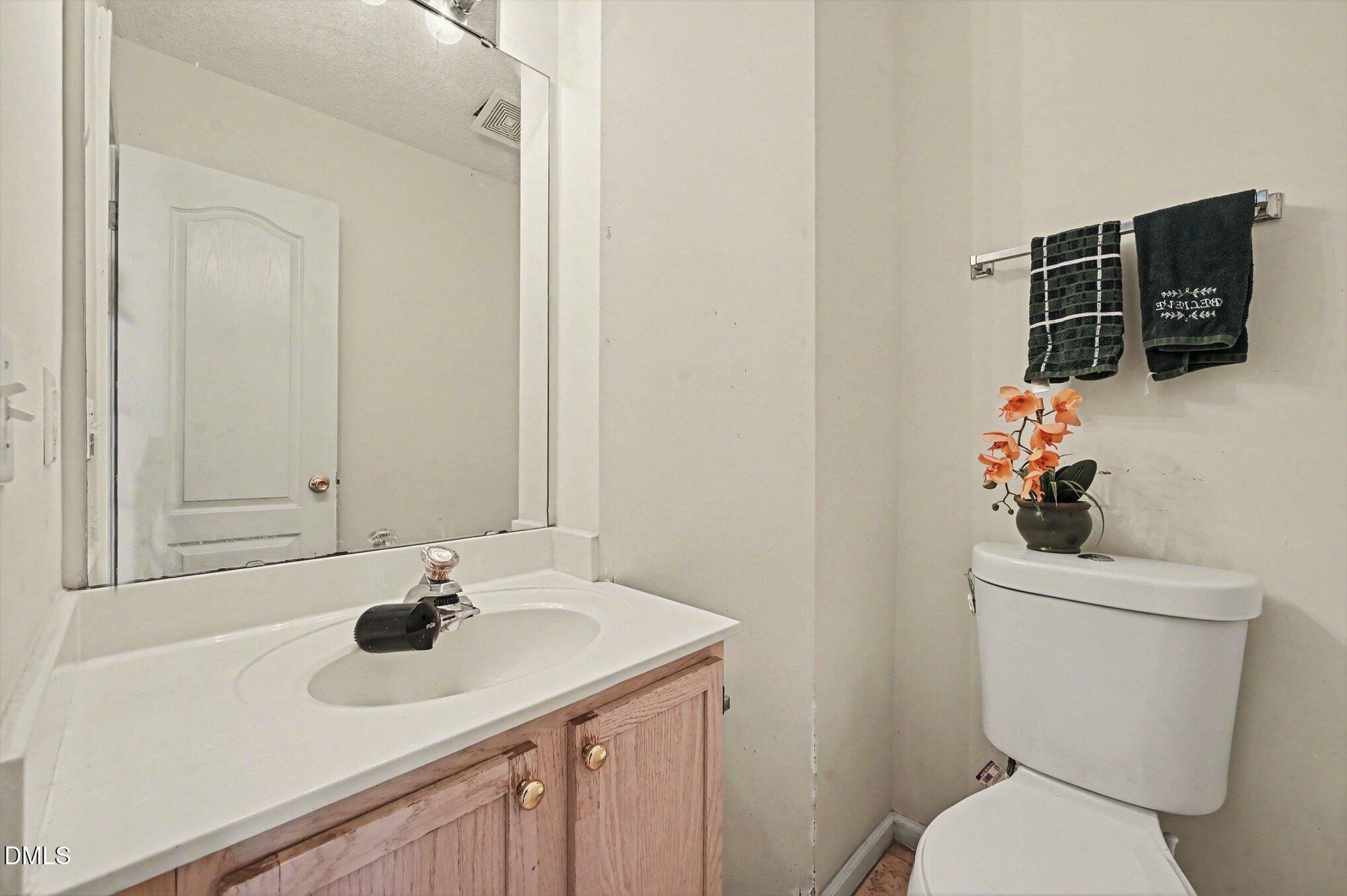 5115 Cardinal Grove Boulevard Raleigh, NC 27616 - Photo 11 of 36 a bathroom with a sink toilet and mirror
